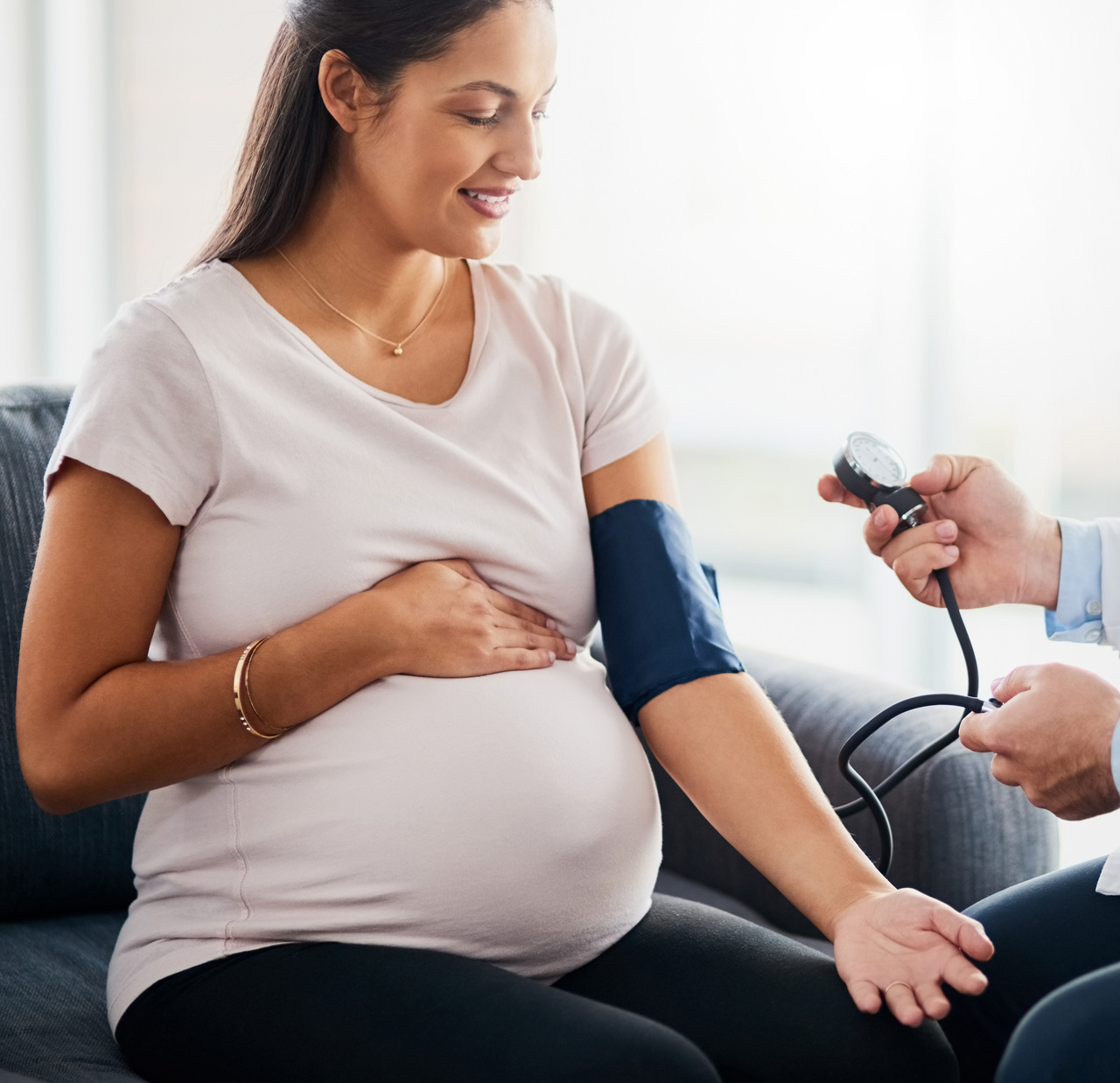 Pregnant woman getting blood pressure checked by doctor
