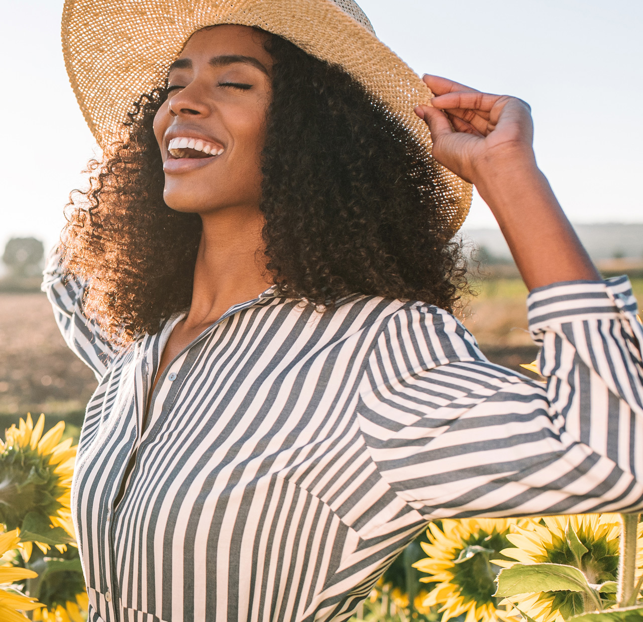 Happy young black woman in a sunflower field Happy young black woman in a sunflower field