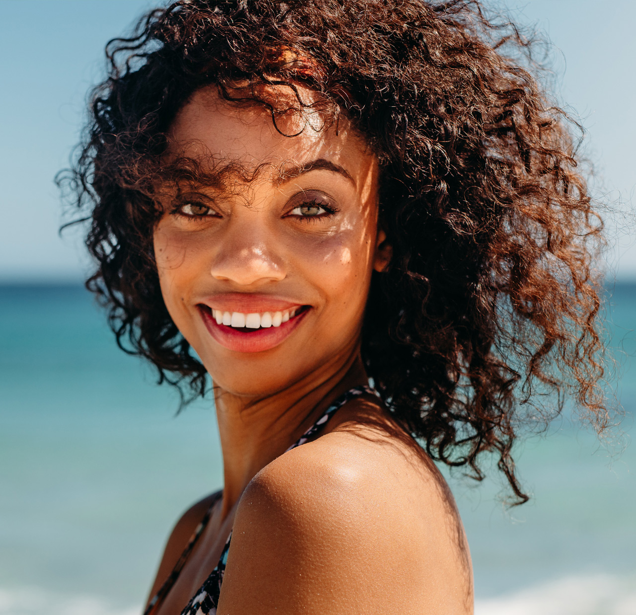 Portrait of a curly haired woman at the beach Portrait of a curly haired woman at the beach