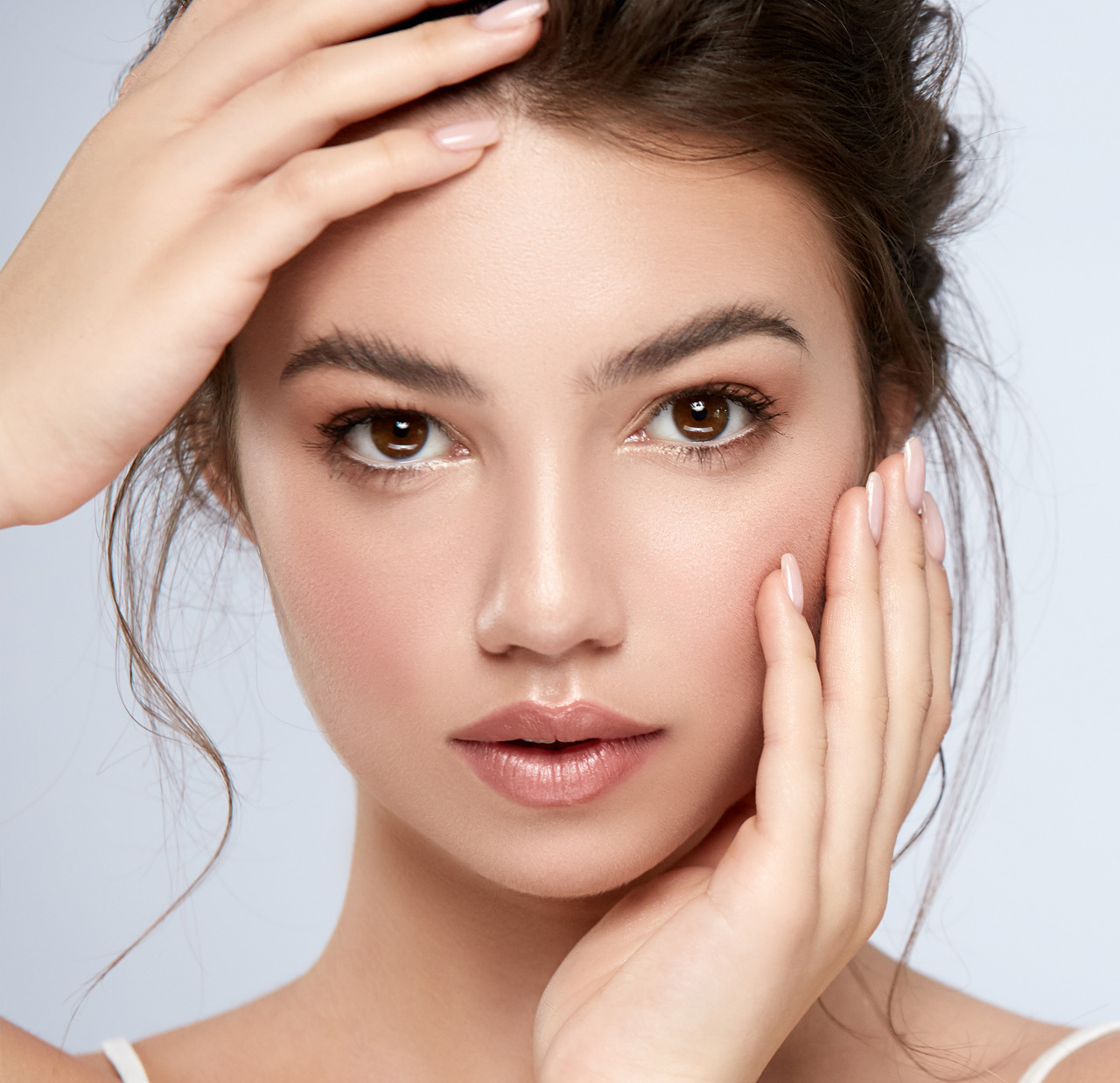 young and fresh model touching her face with arms and looking to camera young and fresh model touching her face with arms and looking to camera