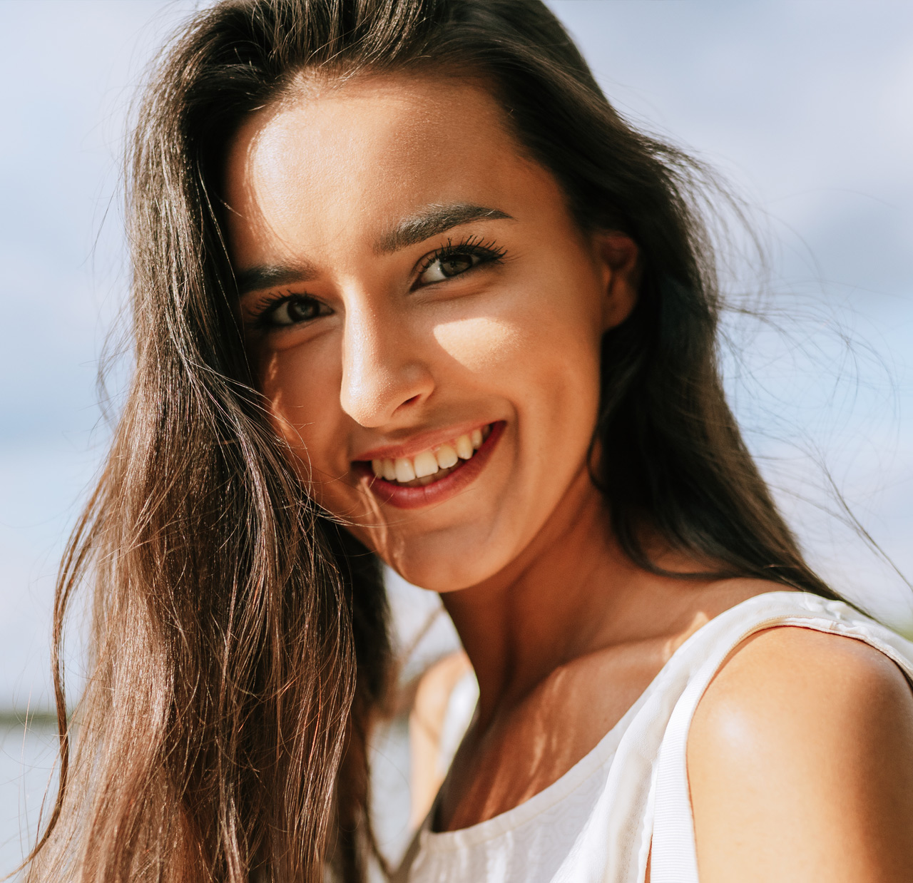 Close-up outdoor portrait of beautiful happy young woman smiling broadly with toothy smile with a windy blowing long hair in the park, posing on nature background Close-up outdoor portrait of beautiful happy young woman smiling broadly with toothy smile with a windy blowing long hair in the park, posing on nature background