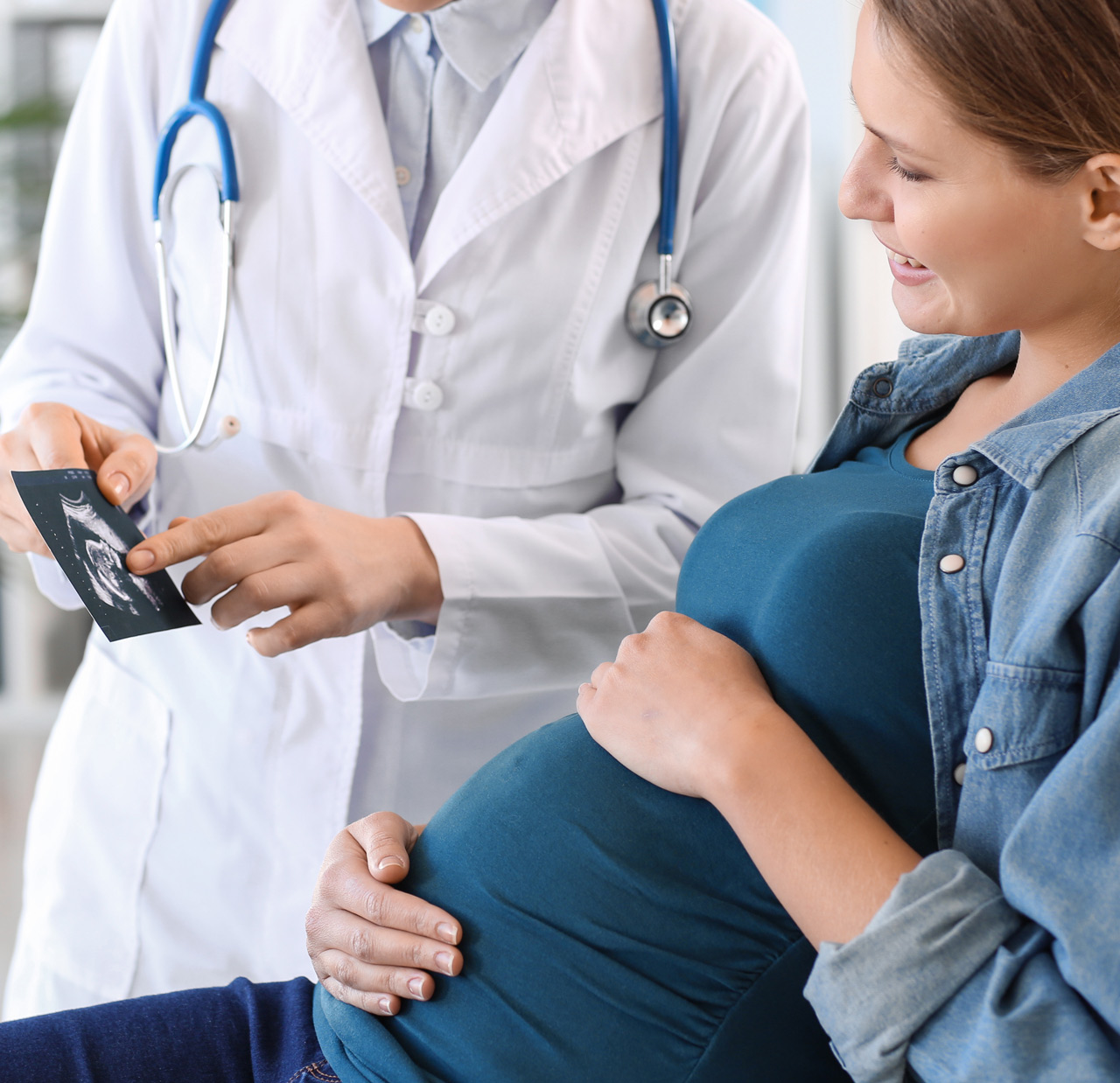 Young pregnant woman visiting her gynecologist in clinic Young pregnant woman visiting her gynecologist in clinic